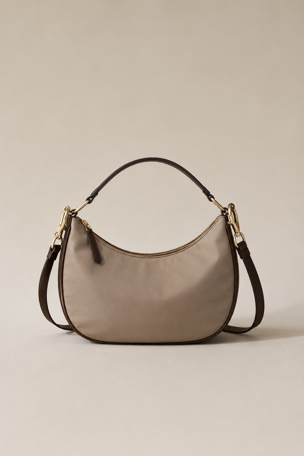 The Lumen crossbody in warm-stone nylon twill with an espresso calfskin handle and strap.