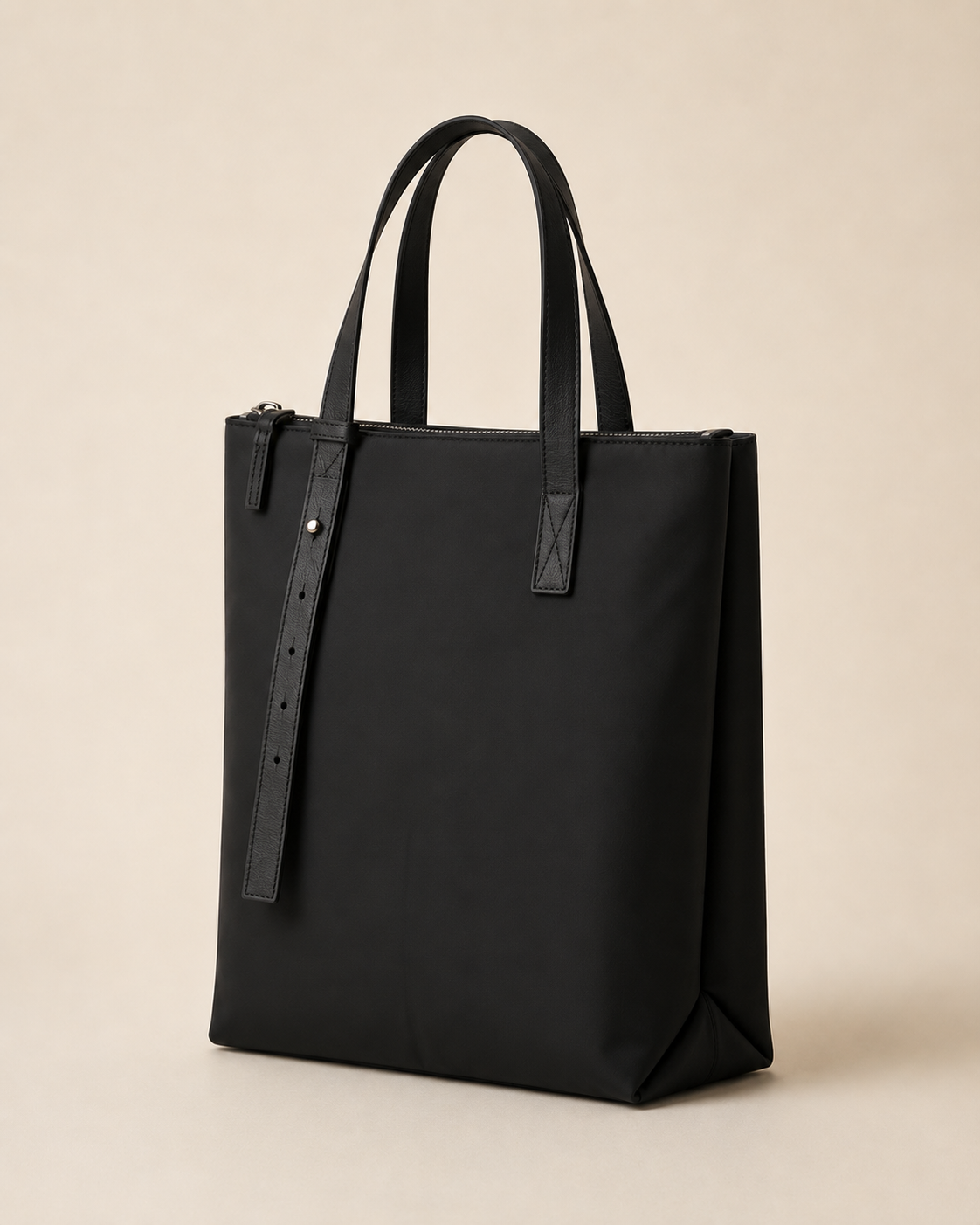 The Marlow tote in black nylon with leather trim, three-quarter view on a warm studio background.