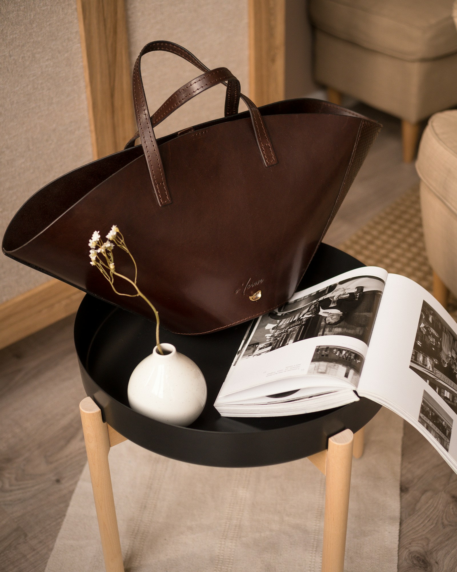 The Marlow tote in dark brown full-grain leather, resting on a side table.